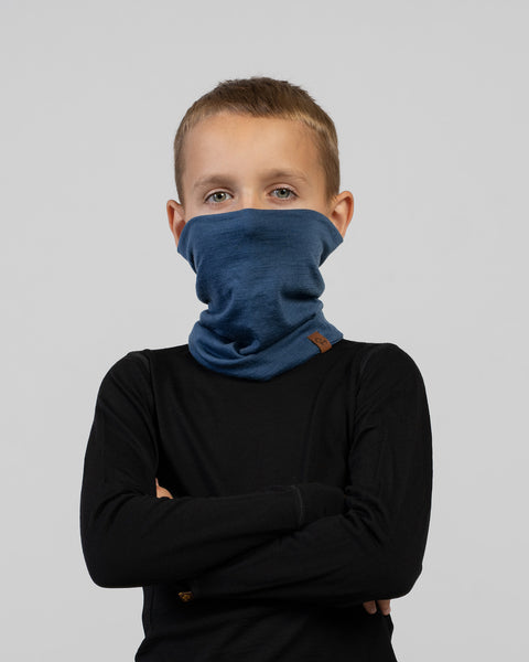 Child wearing a blue Merino wool neck gaiter pulled up to cover mouth and nose – lightweight, warm, and moisture-wicking kids’ scarf.