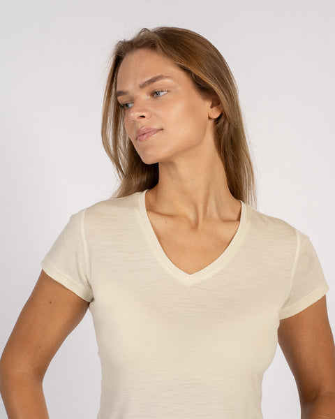 Close-up of a woman in a light natural Merino wool V-neck T-shirt.
