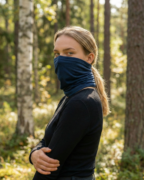 Woman wearing denim blue merino wool long neck gaiter in forest, soft breathable face and neck protection for outdoor activities