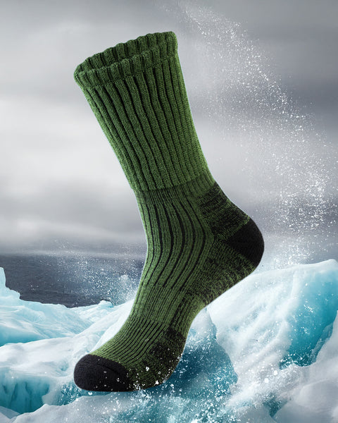 Dark green thermal sock with black toes and heels on a snowy landscape