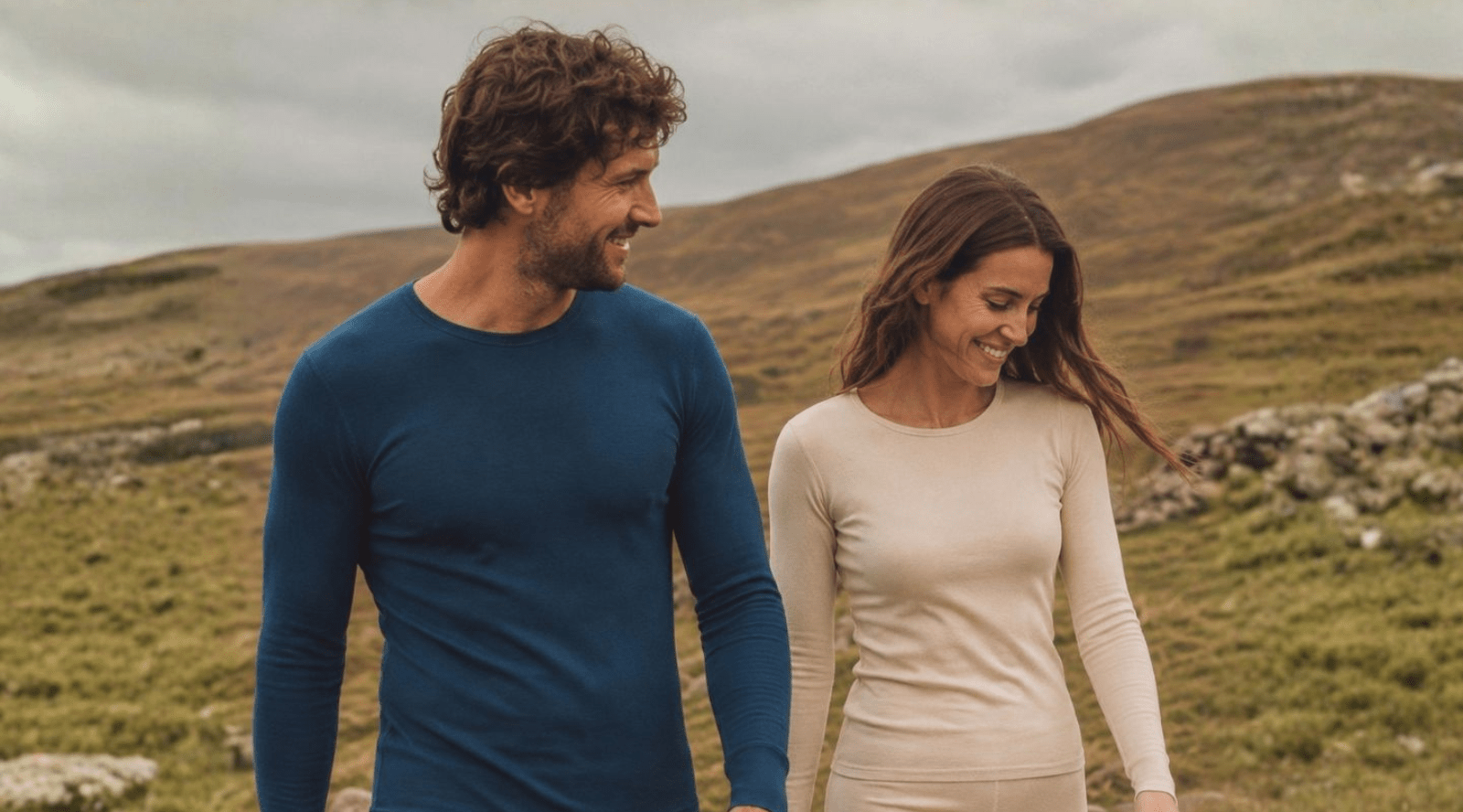 In the photo you can see couple hugging. They are both wearing long sleeve sweaters made from soft and organic 100% Merino Wool. Woman is wearing natural color crewneck, while man is wearing dark blue one,