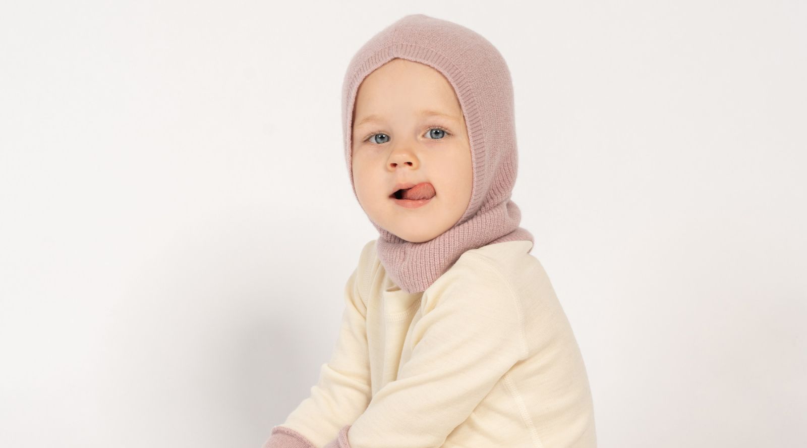 Baby wearing merino wool balaclava and mittens in pink, warm and gentle winter accessories