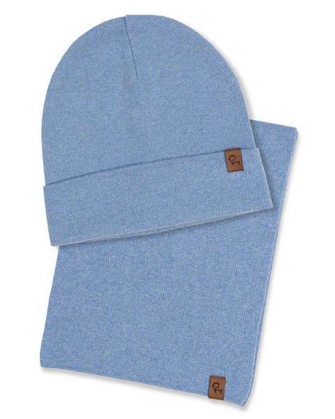 A product shot showing a light blue knitted beanie layered over a matching light blue knitted neck gaiter against a white background. Both items feature a small, rectangular brown leather logo patch near the edge.