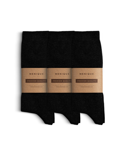 Set of three pairs of black men’s cotton socks, each packaged with Menique eco-friendly kraft paper wraps reading ‘Premium Quality.
