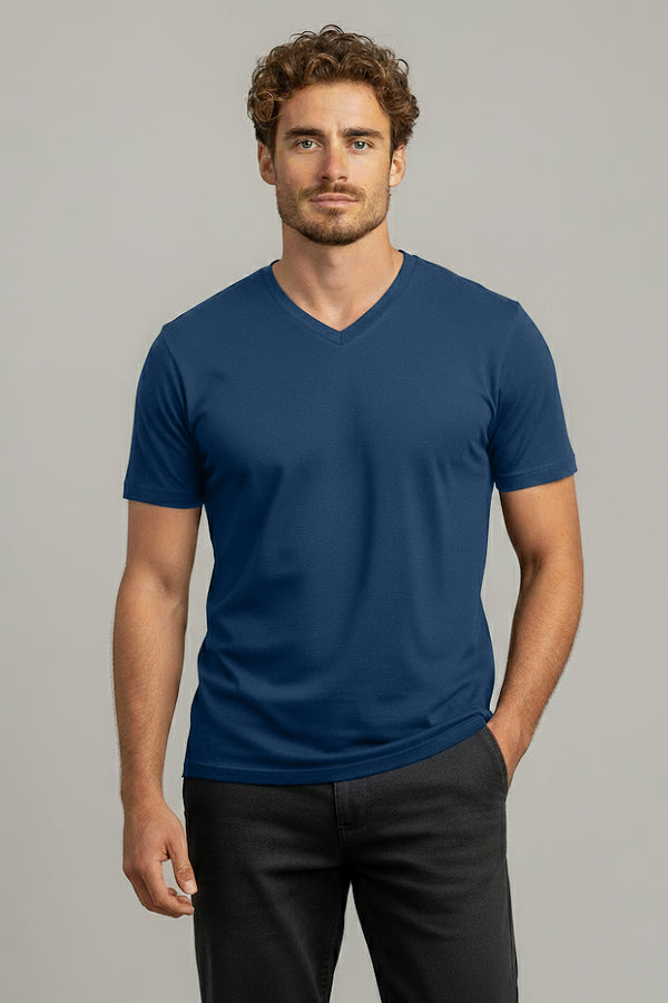 Man wearing a blue V-neck t-shirt against a gray background