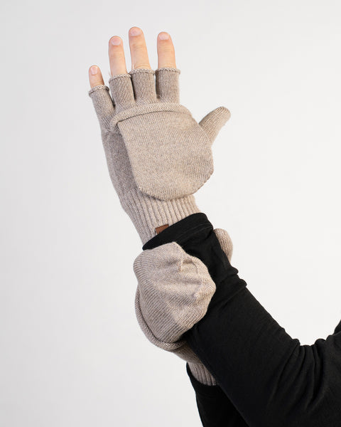 Beige convertible fingerless glove with mitten flap open, worn on a hand raised upward.