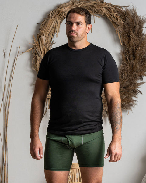 A man wearing the menique men's boxer underwear in color dark green.