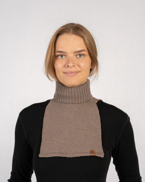 Woman wearing a brown knitted merino wool dickie neck warmer over a black top, front view.