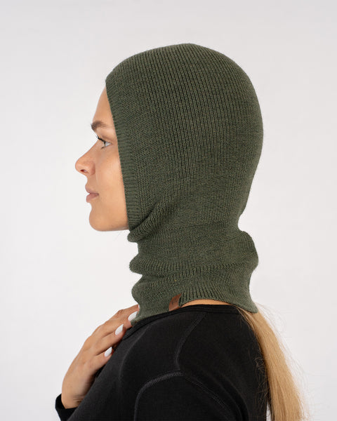 Side view of woman wearing a dark green knitted Merino wool balaclava.