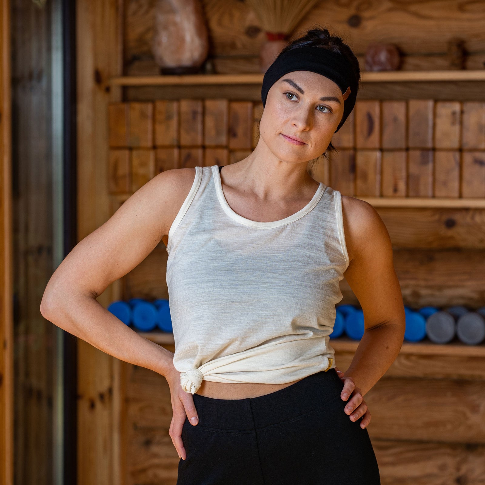 Woman wearing natural beige sleeveless tank top and matching leggings set, breathable soft fabric activewear for yoga, stretching and outdoor workouts